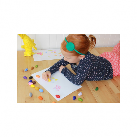 Fille qui dessine avec les crayons cailloux ergonomiques en cire Fille qui dessine avec les crayons cailloux ergonomiques en cire