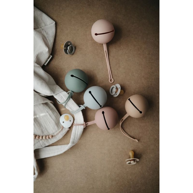 Etui à tétine | Rose par Mushie accroché sur un sac